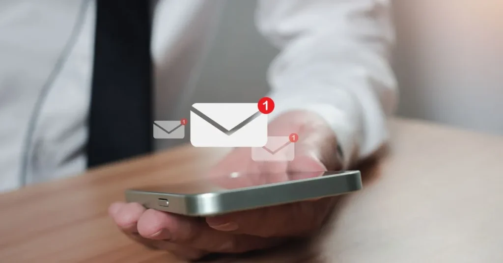 Pessoa segurando um smartphone com notificações de e-mail marketing, representando campanhas eficazes.